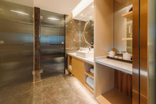 y baño con ducha y lavamanos. en Derreal Hotel - Beijing Shunyi Guozhan Branch, en Beijing