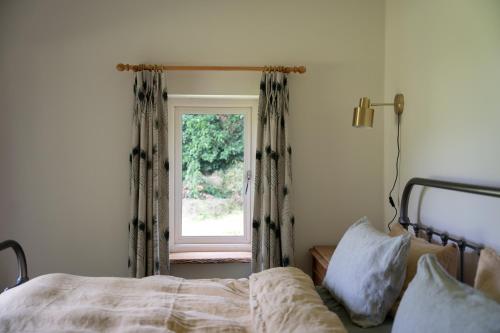 Schlafzimmer mit einem Bett und einem Fenster in der Unterkunft The Roost in Westport
