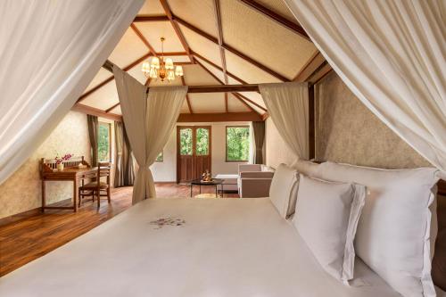 ein Schlafzimmer mit einem großen Bett mit weißen Kissen in der Unterkunft Zana Forest Resort Ranthambore in Sawāi Mādhopur