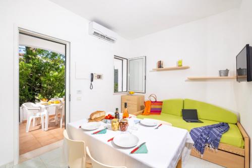 a living room with a table and a green couch at Baia Degli Aranci Suite & Apartments in Vieste