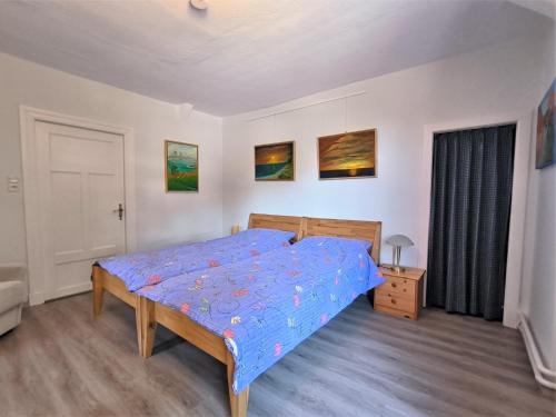 a bedroom with a bed with a blue comforter at Ferienwohnung Hensen in Tarp