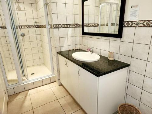 La salle de bains blanche est pourvue d'un lavabo et d'une douche. dans l'établissement Villa T3 - Selborne Golf Estate, à Pennington