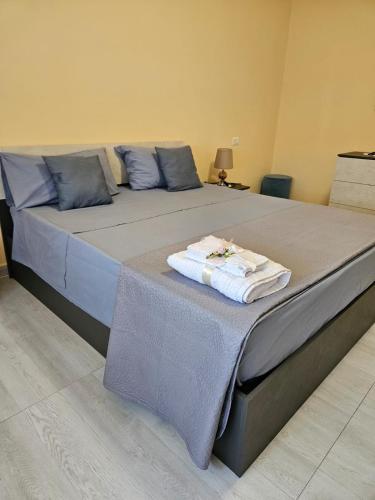 Una cama grande con toallas encima. en Royal House Reggia, en Caserta
