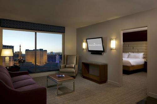 Hilton Grand Vacations Club Elara Center Strip Las Vegas في لاس فيغاس: غرفه فندقيه سرير وتلفزيون
