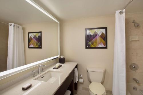 a bathroom with a sink and a toilet and a mirror at Embassy Suites by Hilton Washington D.C. Georgetown in Washington