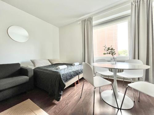 a white bedroom with a bed and a table at Tammer Huoneistot - City Suite 2 - City View & Perfect location in Tampere