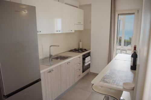 a white kitchen with a sink and a stove at Villa Quantum in Siculiana Marina