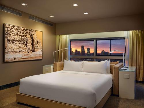 Un dormitorio con una gran cama blanca y una ventana en Millennium Hilton New York One UN Plaza, en Nueva York
