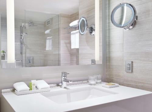 a bathroom with a white sink and a mirror at Millennium Hilton New York One UN Plaza in New York