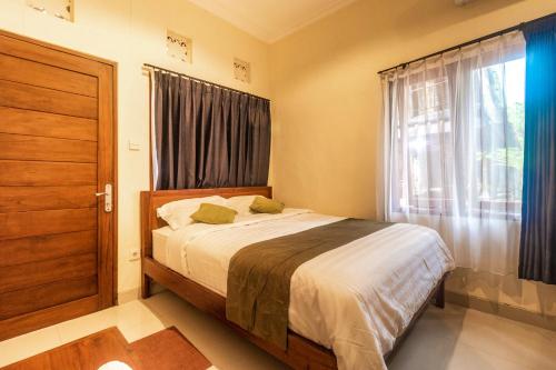 Alam Desa Homestay في Perean: غرفة نوم صغيرة بها سرير ونافذة