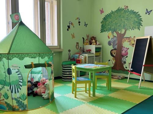 a childs room with a table and a tree at Hotel DAP in Prague