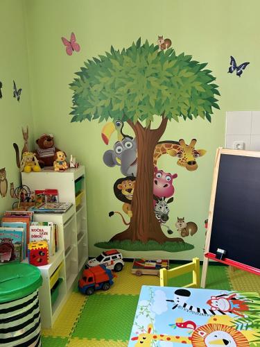a childs room with a cartoon tree and animals on the wall at Hotel DAP in Prague