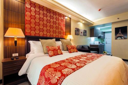 a bedroom with a large bed with a red blanket at Tivoli Garden Residences - Iris Tower in Manila