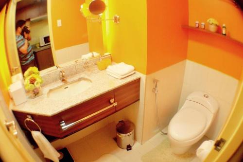 a bathroom with a sink and a toilet and a mirror at Tivoli Garden Residences - Iris Tower in Manila