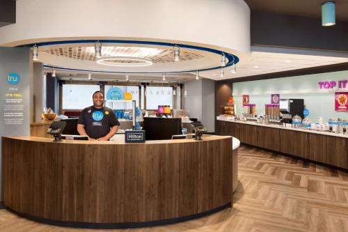 a man is standing at a counter in a dental office at Tru By Hilton Las Vegas Airport NV in Las Vegas