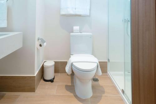 a bathroom with a white toilet and a shower at Wyndham Garden El Morro Montecristi in El Rincón