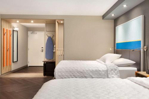 a hotel room with two beds and a surfboard on the wall at Tru By Hilton Las Vegas Airport NV in Las Vegas