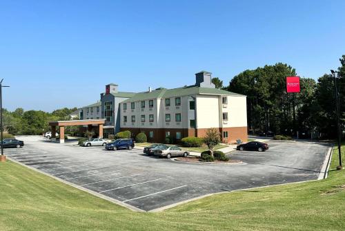 a large building with cars parked in a parking lot at Ramada by Wyndham Lithia Springs Atlanta in Lithia Springs