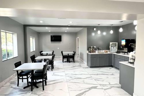 a restaurant with tables and chairs and a kitchen at Ramada by Wyndham Lithia Springs Atlanta in Lithia Springs