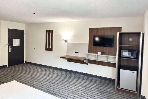 an empty hotel room with a television and a room at Ramada by Wyndham Lithia Springs Atlanta in Lithia Springs