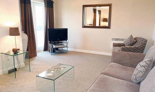 a living room with a couch and a tv at Regent - Properties Unique in Newcastle upon Tyne