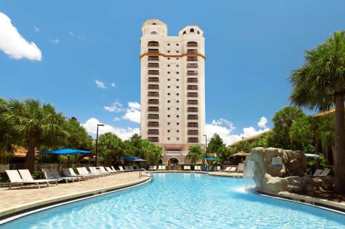 ein Hotel mit einem Pool vor einem Gebäude in der Unterkunft DoubleTree by Hilton Hotel Orlando at SeaWorld in Orlando