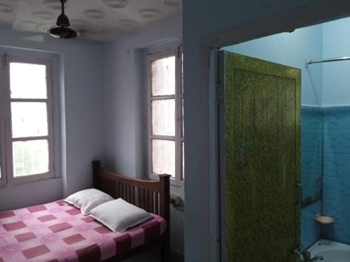 Centerpoint Guest House في كولْكاتا: غرفة نوم مع سرير ودش وحوض استحمام