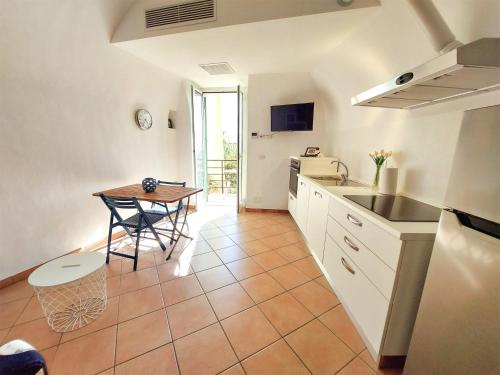 a kitchen and dining room with a table and a sink at Il 55 dei Bastioni in Bordighera