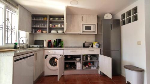 a kitchen with a washing machine and a refrigerator at Apartamento Bambadela in Cala del Moral