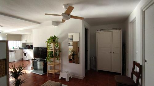 a living room with a ceiling fan and a kitchen at Apartamento Bambadela in Cala del Moral