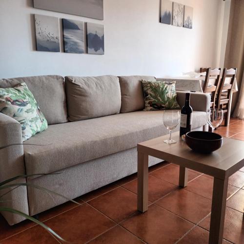 a living room with a couch and a table with wine glasses at Apartamento Bambadela in Cala del Moral