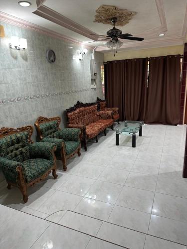 a living room with couches and a table in it at Thumbs Up HomeStay in Kampong Jalan Berop