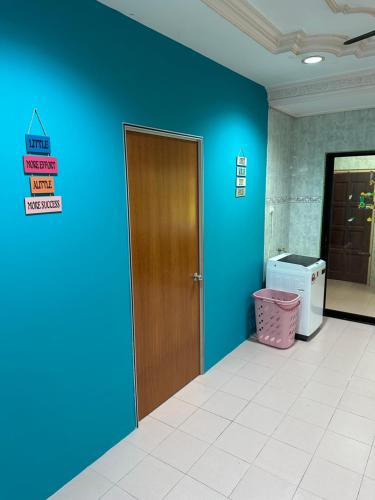 een lege kamer met een blauwe muur en een deur bij Thumbs Up HomeStay 