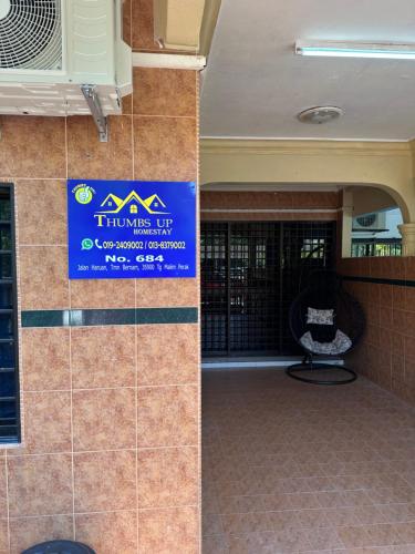 a sign is on the side of a building at Thumbs Up HomeStay in Kampong Jalan Berop
