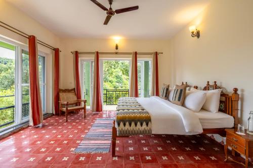 a bedroom with a bed and large windows at ama Stays & Trails Anjanagiri , Kotagiri in Kotagiri