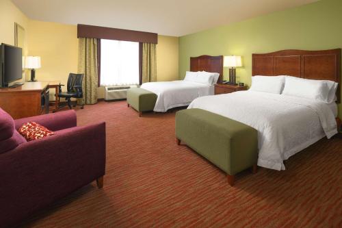 a hotel room with two beds and a couch at Hampton Inn Kimball in Kimball