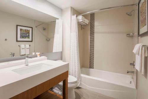 a bathroom with a sink and a toilet and a tub at Hyatt Place Waco - South in Waco