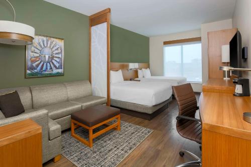 a hotel room with a bed and a couch and a room at Hyatt Place Waco - South in Waco