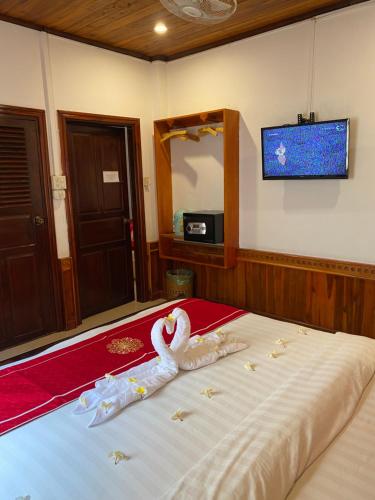sypialnia z łóżkiem z łabędziem w obiekcie Golden Lotus Boutique Hotel w mieście Luang Prabang