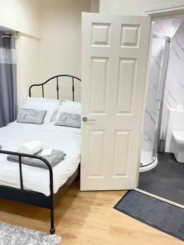 a bedroom with a bed and a white door at Breeze Hill Lodge - Central to Liverpool City Centre - Anfield - Goodison in Liverpool