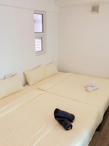 a white room with two beds with a hat on it at Top Sea View - Maritime Suite 只有海景房 in Jelutong