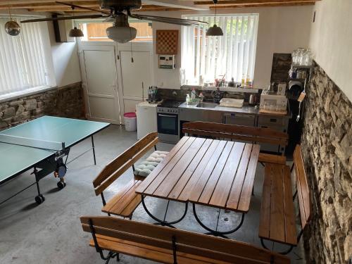 a kitchen with a table and benches and a kitchen with a counter at Pension Pošta in Branná