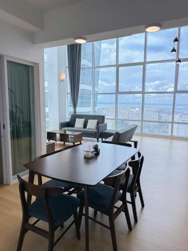 a living room with a table and chairs and a couch at Top Sea View - Maritime Suite 只有海景房 in Jelutong