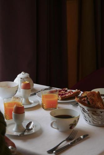 ein Tisch mit Frühstücksspeisen und Getränken darauf in der Unterkunft Hôtel de Cavoye in Fontainebleau