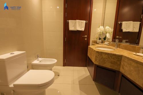a bathroom with a toilet and a sink at 2 BR Perfect for Family/Groups near MOE in Dubai