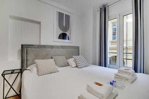 una camera da letto con un letto bianco e asciugamani di CMG Palais Royal / Musée du Louvre a Parigi