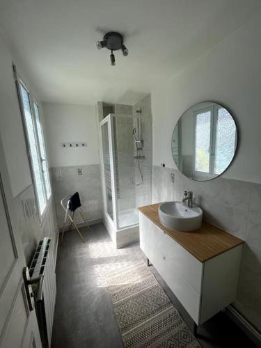 Un baño blanco con lavabo y espejo. en Appt cosy vue mer Malo-Les-Bains, en Dunkerque