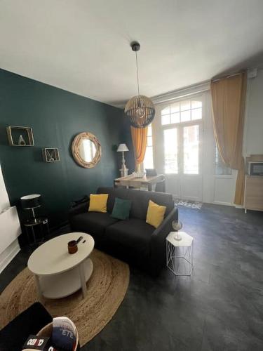 una sala de estar con un sofá y una mesa en Appt cosy vue mer Malo-Les-Bains, en Dunkerque