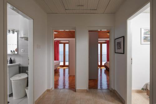 uma sala de estar com paredes brancas e piso em madeira em Holiday Home Kvarner em Ičići