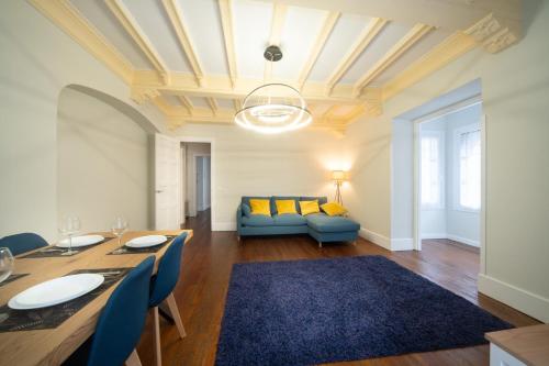 a living room with a table and a blue couch at Apartamento con garaje en el centro de Zumaia in Zumaia